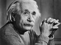 Svartvitt fotografi med Albert Einstein som har flätade fingrar